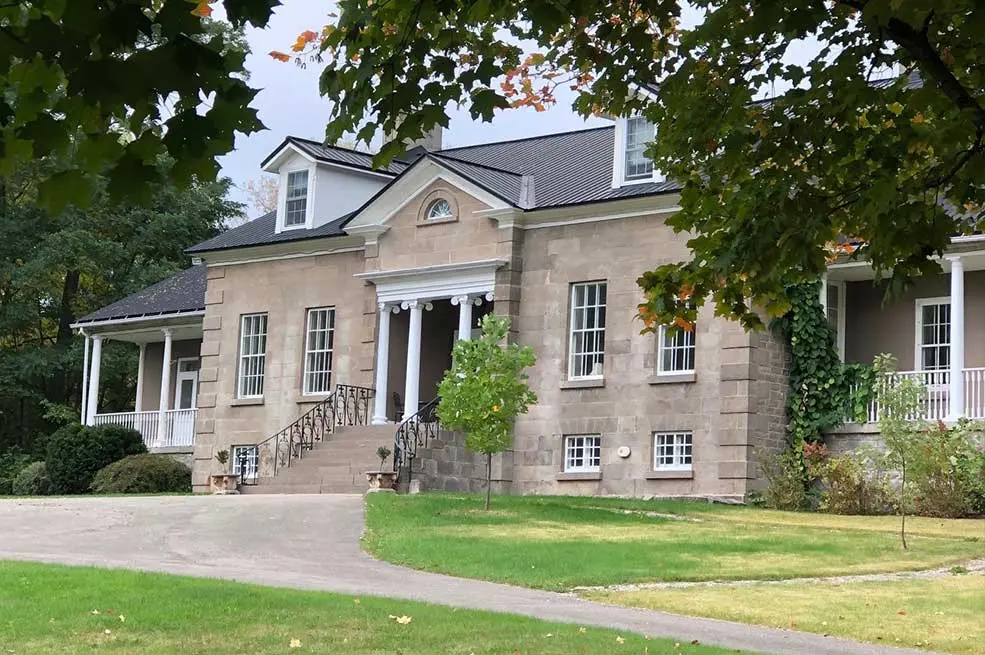 A large stone house nestled between trees