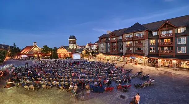 A group of people watching movies on a large screen outdoors
