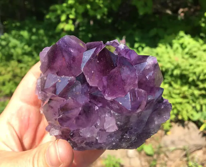 자수정 크리스탈을 들고 있는 손 클로즈업