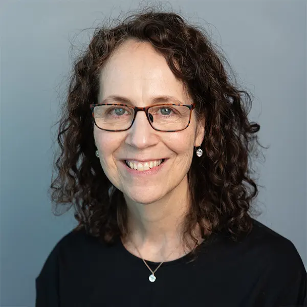 Portrait de Garlene Kubisheskie, souriant et portant un chemisier noir.