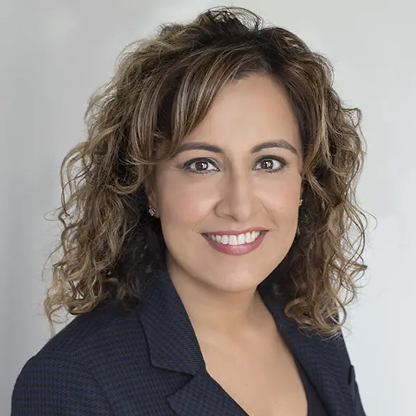 Headshot of Dr. Jasveen Rattan, smiling and wearing a black shirt and blazer.