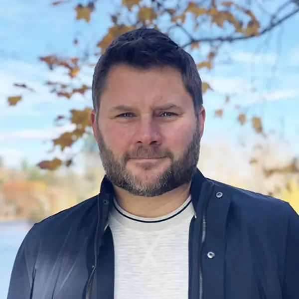 Headshot of Jesse Hamilton, wearing a fall coat with a thoughtful gaze.