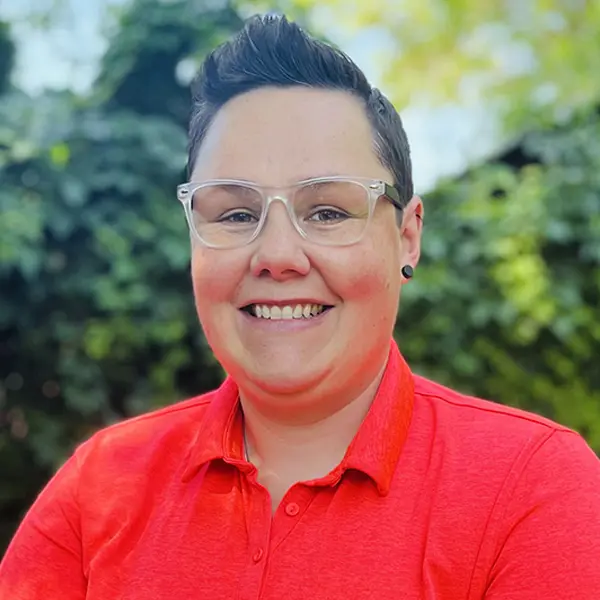 Headshot of Lacey Rigg, smiling and wearing a red polo.