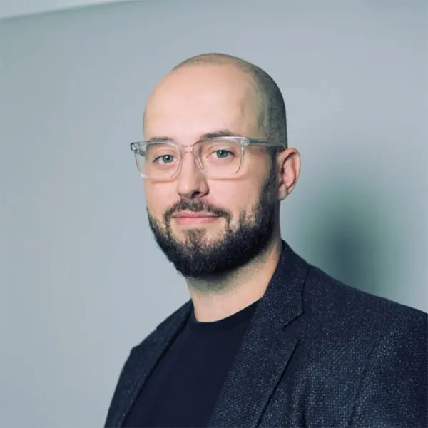 Portrait de Lauchlan Rogers, souriant et portant un blazer foncé.