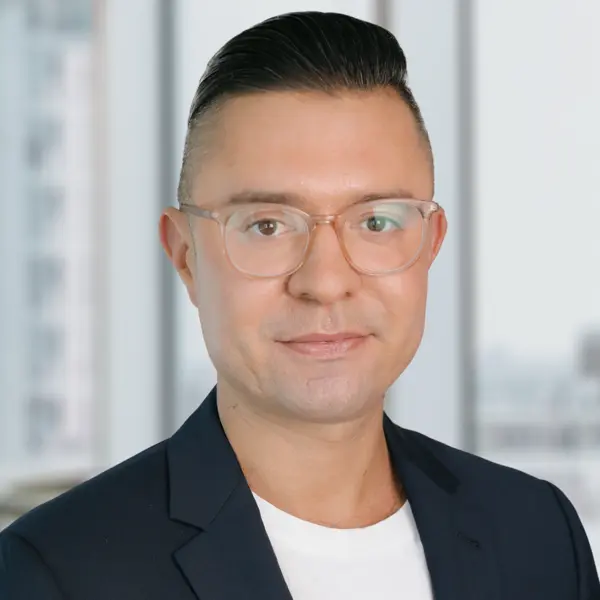 Portrait d’Andrew Galloro, affichant un air détendu et portant une chemise foncée.