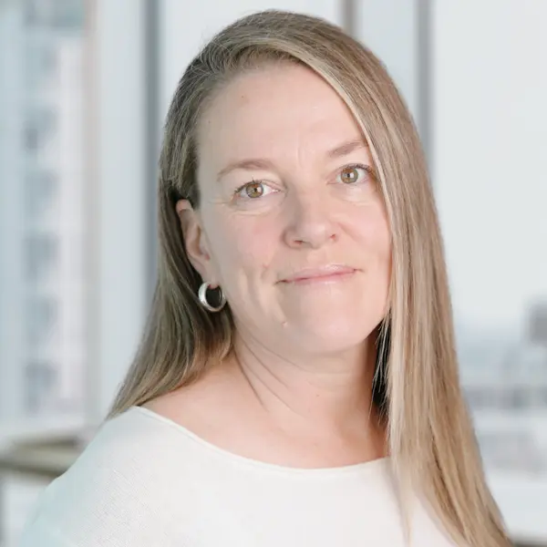Portrait de Danielle Chrétien, souriant et portant un chemisier foncé.