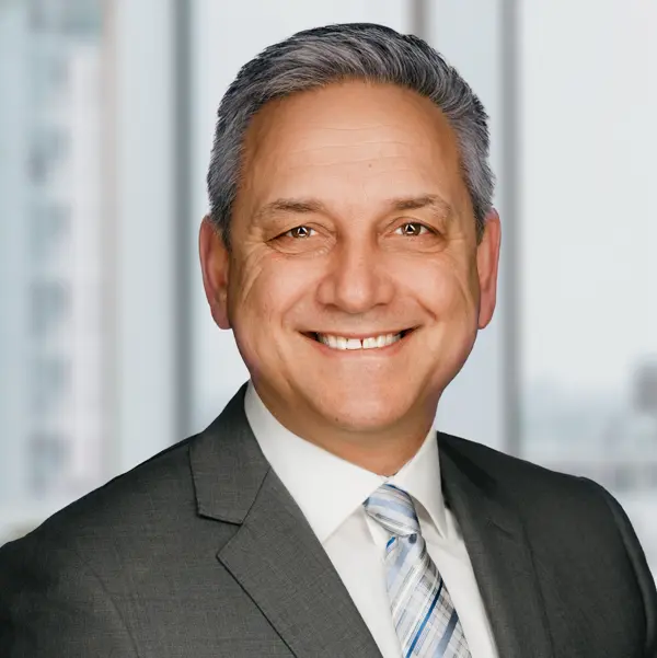 Portrait de Jerry Pribil, souriant et portant un costume.