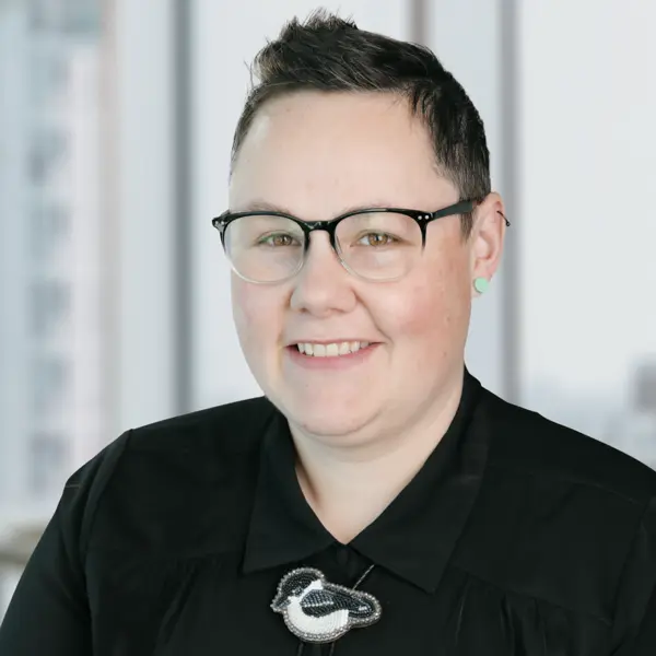Portrait de Lacey Rigg, souriant et portant un polo rouge.
