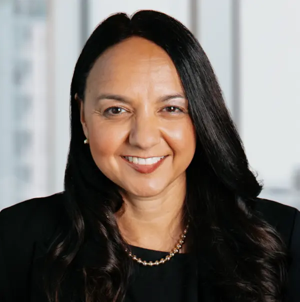 Portrait de Lydia Devereaux, souriant et portant un blazer foncé.
