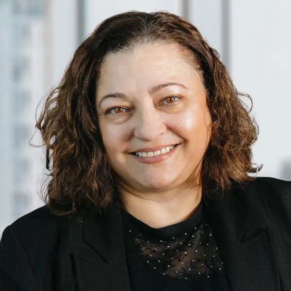 Portrait de Vinceza Ronaldi, souriant et portant un blazer noir.