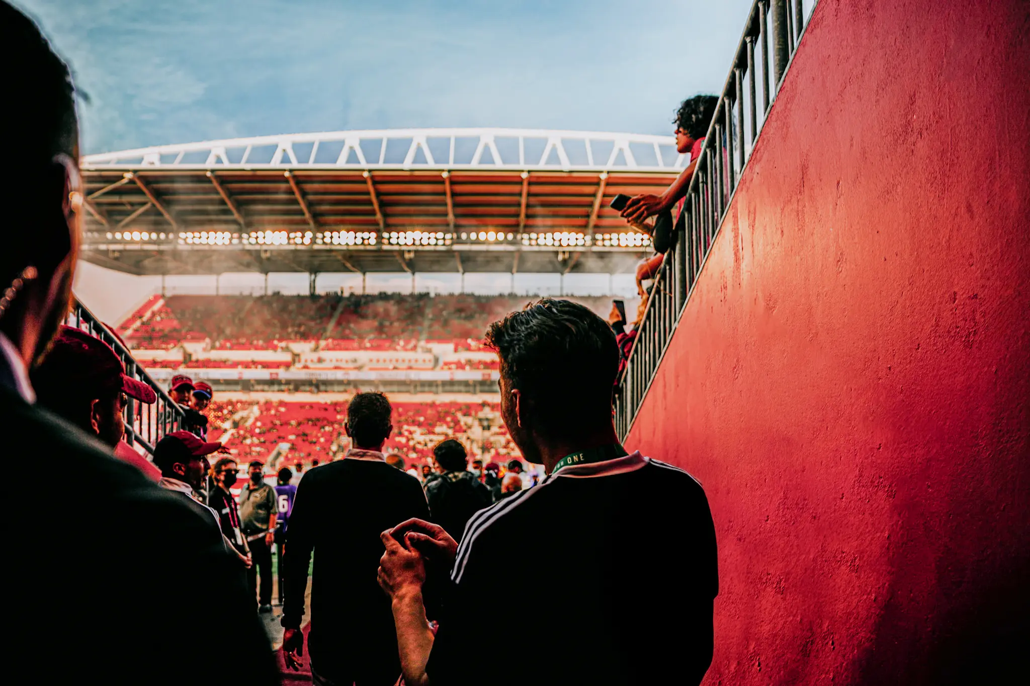 Spectators walking into a crowded stadium for a soccer game.