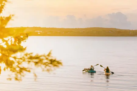 L19  Two people kayaking on calm water at sunset near Manitoulin Island.