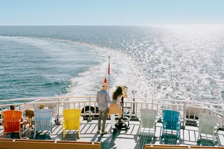 Passengers standing on the deck of the MS Chi-Cheemaun ferry crossing Lake Huron near Manitoulin Island.