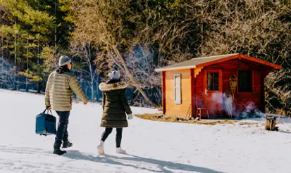 Deux personnes marchant dans la neige vers une cabane au sanctuaire Wild Rose, dans le comté de Perth, en Ontario.