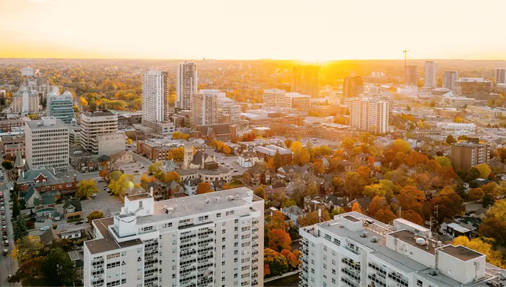 夕暮れ時の、高くそびえる白い都市の建物群を空撮した写真。
