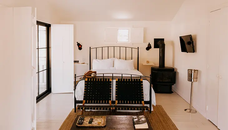 Helles, modernes Gästezimmer mit Metallbettgestell und minimalistischer Einrichtung.