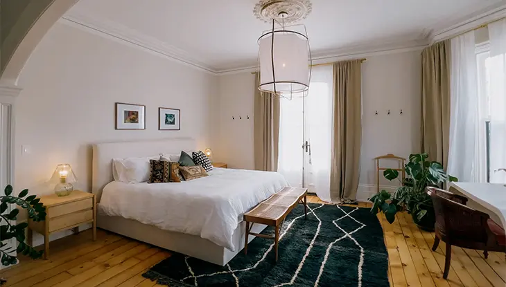 Elegant guest bedroom with a king-size bed, neutral decor and large windows.