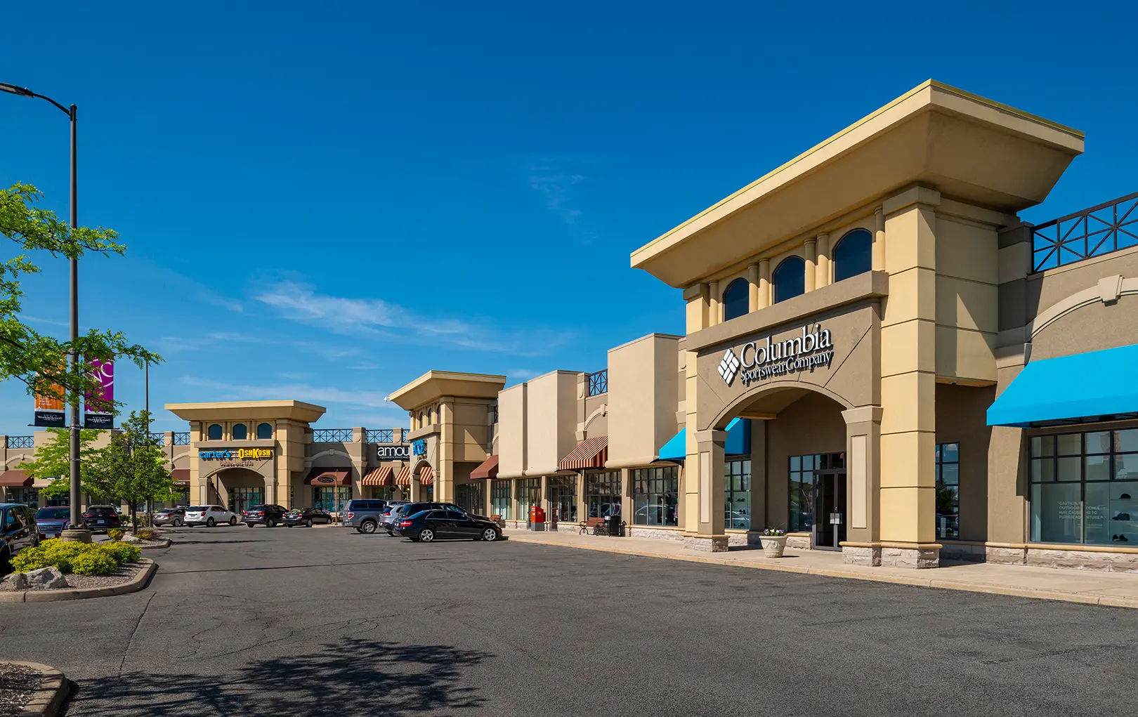 Extérieur du centre commercial Windsor Crossing Premium Outlet Mall par une journée ensoleillée.