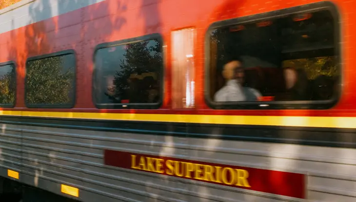 O35 Le train touristique du canyon Agawa, gris et rouge, traverse la forêt au feuillage d'automne à Sault Ste. Marie.