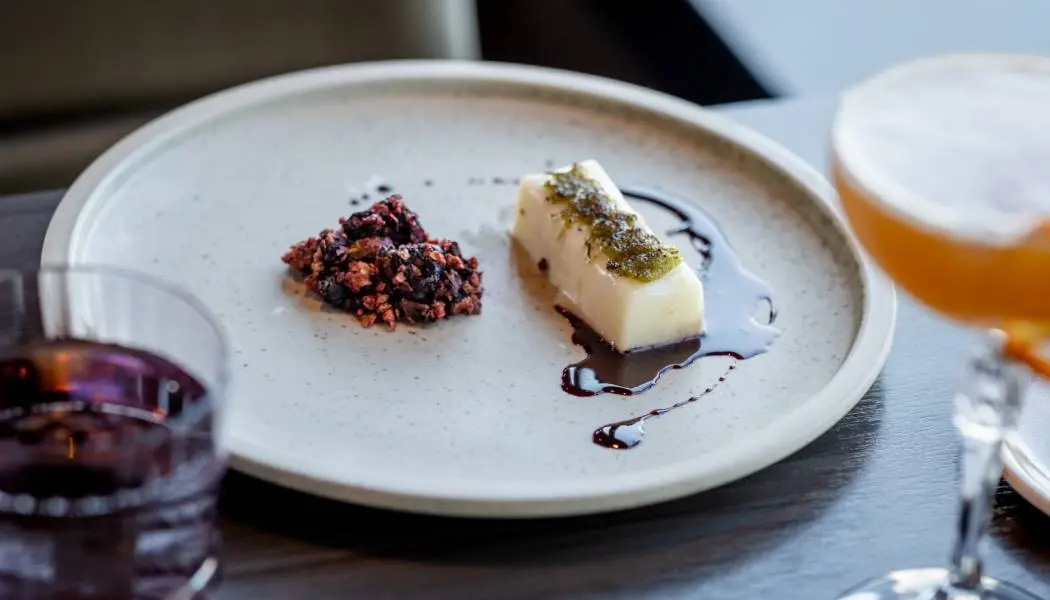 Un plat artistiquement présenté est servi avec des cocktails dans un restaurant haut de gamme de Kingston, en Ontario.