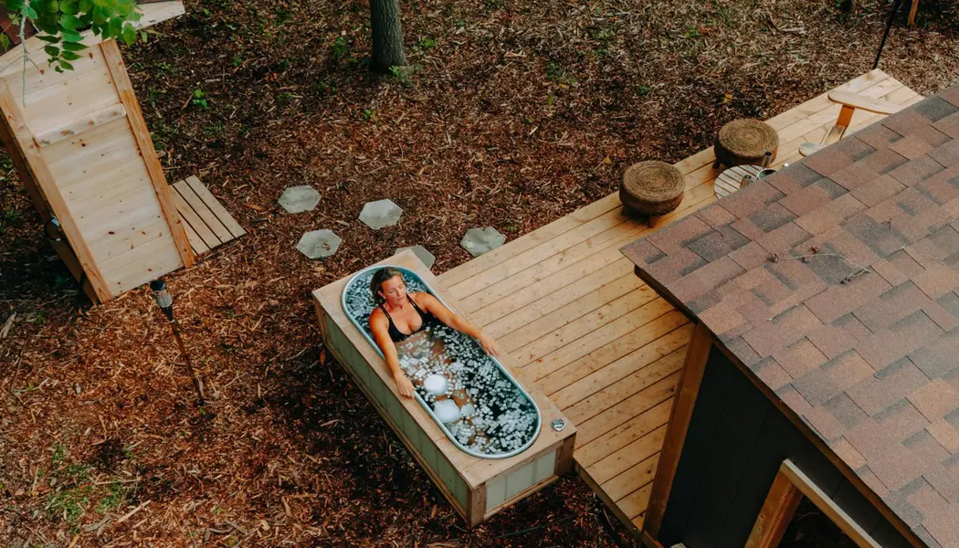 Eine Frau genießt ein eiskaltes Bad im Freien in einem nordischen Spa im Südwesten Ontarios.