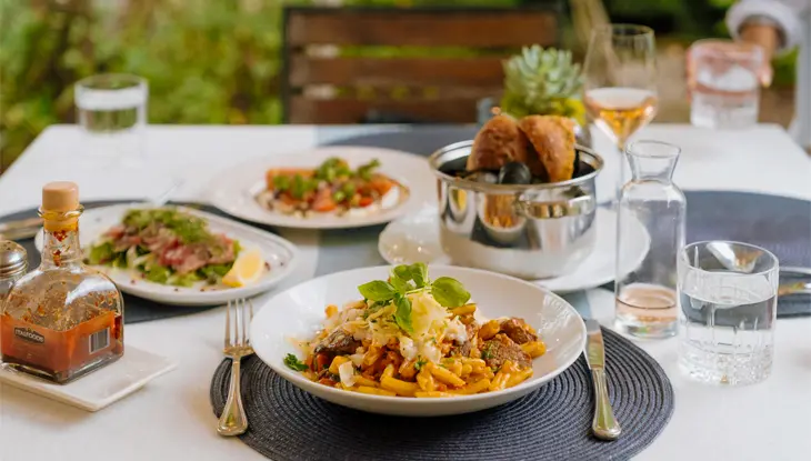 A table is set for lunch, featuring several dishes and beverages, at Crossroads Restaurant.