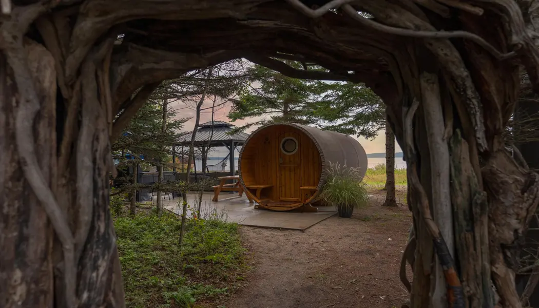 オフグリッドの自然とウェルネスの隠れ家にある木製の寝台樽の眺め。