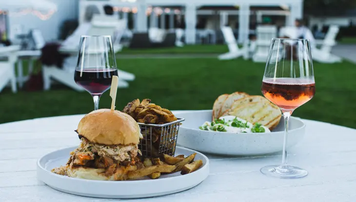 Zwei Gläser Wein und Bistrogerichte stehen auf einem Tisch auf der Außenterrasse des 13th Street Winery.