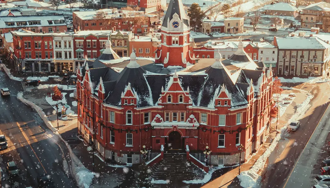 Aerial view of the stately Victorian-style Town Hall in downtown Stratford under a dusting of white snow.