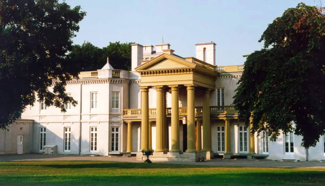 La façade du site historique du Château-Dundurn encadrée par deux arbres par une journée ensoleillée.