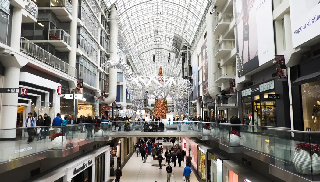 Crowds of shoppers are Christmas shopping in Toronto’s Eaton Centre, a multi-level downtown shopping centre.
