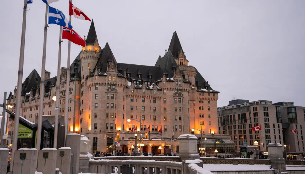 Eine Reihe von Flaggen, darunter die kanadische Flagge, führt zum Fairmont Château Laurier, einem der traditionsreichsten Hotels Ottawas.