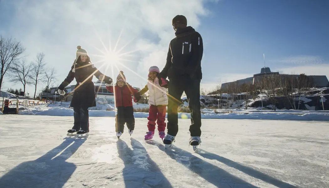 A family of four links hands as they enjoy ice skating on Ramsey Lake Skating Path in Sudbury.
