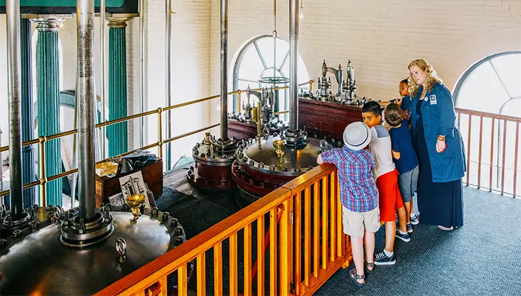 Guide du musée faisant découvrir à un groupe d’enfants l’exposition du Musée de la vapeur et de la technologie de Hamilton.