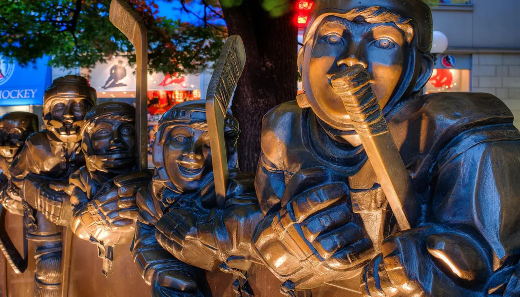 Una escultura de bronce de tamaño natural de cinco jugadores de hockey sosteniendo sus palos se encuentra afuera del Salón de la Fama del Hockey de Toronto.