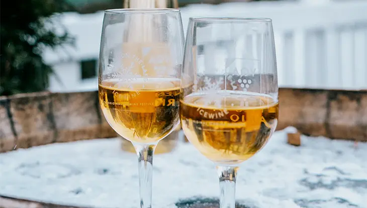 Deux verres de vin reposent sur un tonneau à vin en bois recouvert de neige, à l'extérieur, lors du festival annuel du vin de glace de Niagara.
