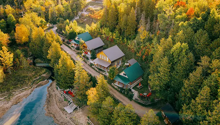 Cottages surrounded by fall colours along the shoreline at Cedar Shores Cottages on Manitoulin Island.