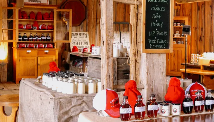 Interior of the Maple Syrup Museum of Ontario at Elliott Tree Farm, showcasing maple syrup products, candles, and local goods in a rustic wooden space.