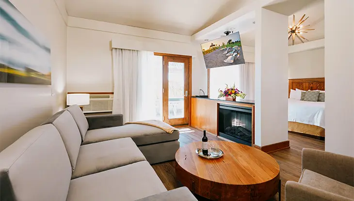 Salon avec canapé moderne et meubles d'appoint en bois.