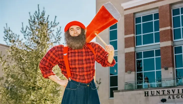 Personnage déguisé en bûcheron qui tient une hache surdimensionnée.