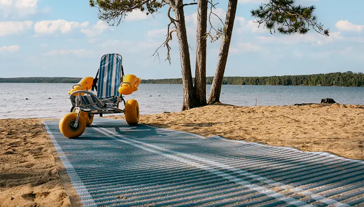 Accessible beach mobility chair beside a mat pathway at an Ontario Parks beach.