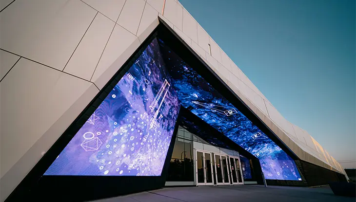 Entrada exterior iluminada del Museo Canadiense de Ciencia y Tecnología al anochecer en Ottawa.