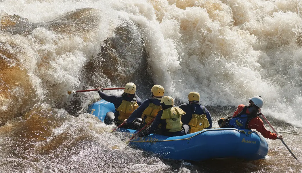 Eine Gruppe von Paddlern trotzt einer riesigen Welle beim Wildwasser-Rafting auf dem Ottawa River.