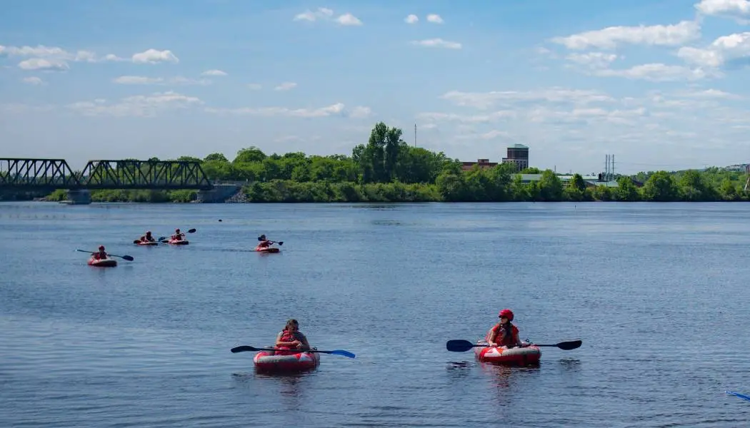 A group of people paddle small rafts down the Ottawa River.