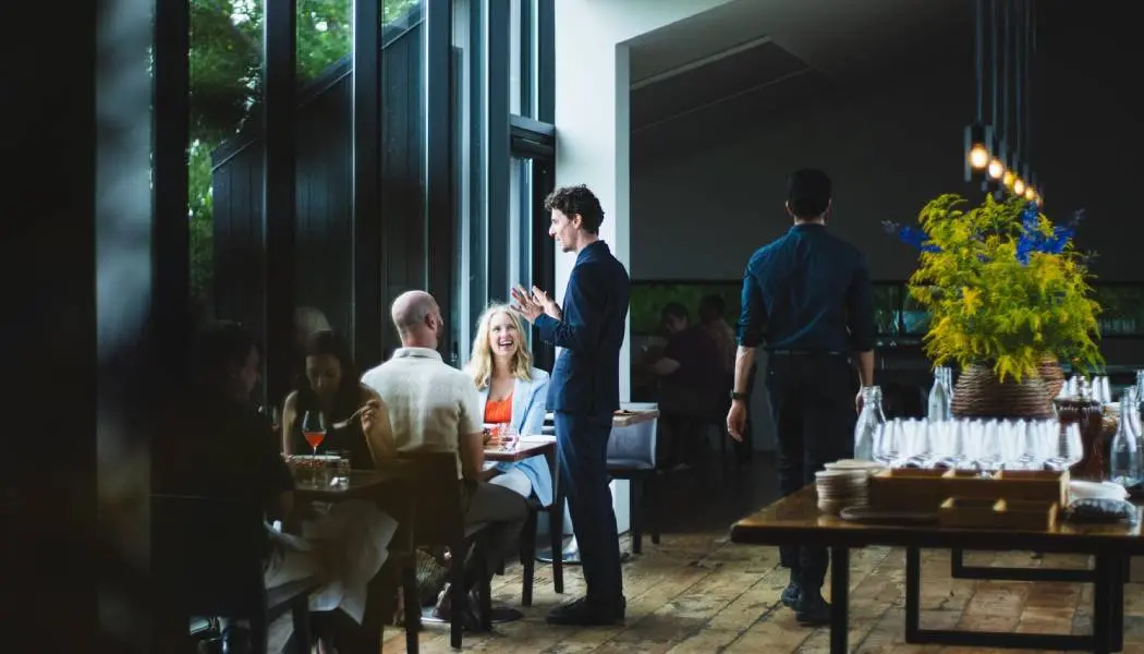 A server describes the menu to a couple dining sitting in an airy Niagara winery restaurant.