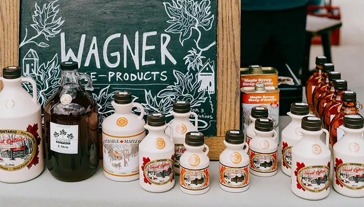 Bottles of maple syrup displayed at a vendor booth at the Peterborough Farmers’ Market in Ontario.