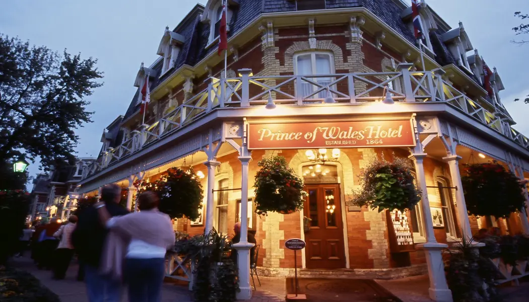 Menschen gehen am beleuchteten Haupteingang des Prince of Wales Hotels aus der viktorianischen Ära in Niagara-on-the-Lake vorbei.