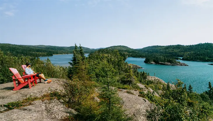 Personne assise sur une chaise rouge le long du sentier Southern Headland dans le parc national Pukaskwa.