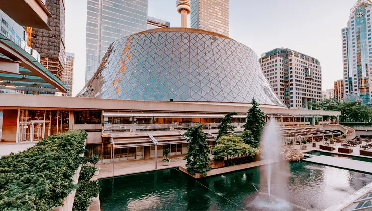 Édifice circulaire consacré aux arts de la scène, entouré de promenades piétonnes, de plans d’eau et d’immeubles du centre-ville.