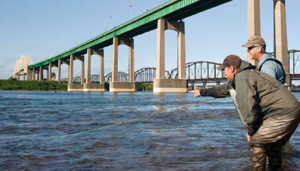 Two men are sport fishing on St. Mary’s River in Sault Ste. Marie, Ontario.